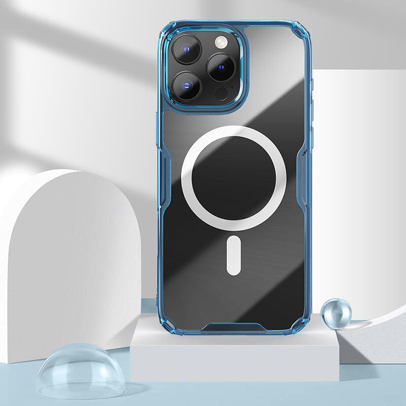 A Clear Magnetic iPhone 16 Pro Max Case, which is shockproof, MagSafe-compatible, and features a crystal-clear design in blue with white circular and line patterns, is displayed on a geometric background with white objects and reflective spheres.