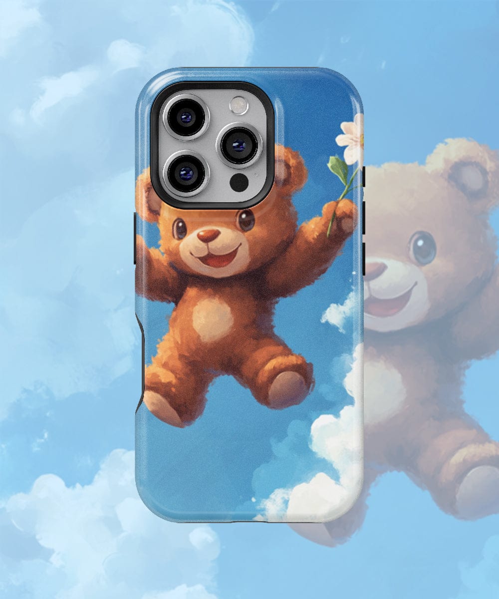 Adorable Teddy Bear iPhone 16 Pro Max Case – MagSafe Compatible, Slim Fit, Shockproof PC + Silicone Design: This phone case features an illustrated teddy bear holding a flower against a blue sky background with clouds. It offers dual-layer protection to keep your device safe and stylish.