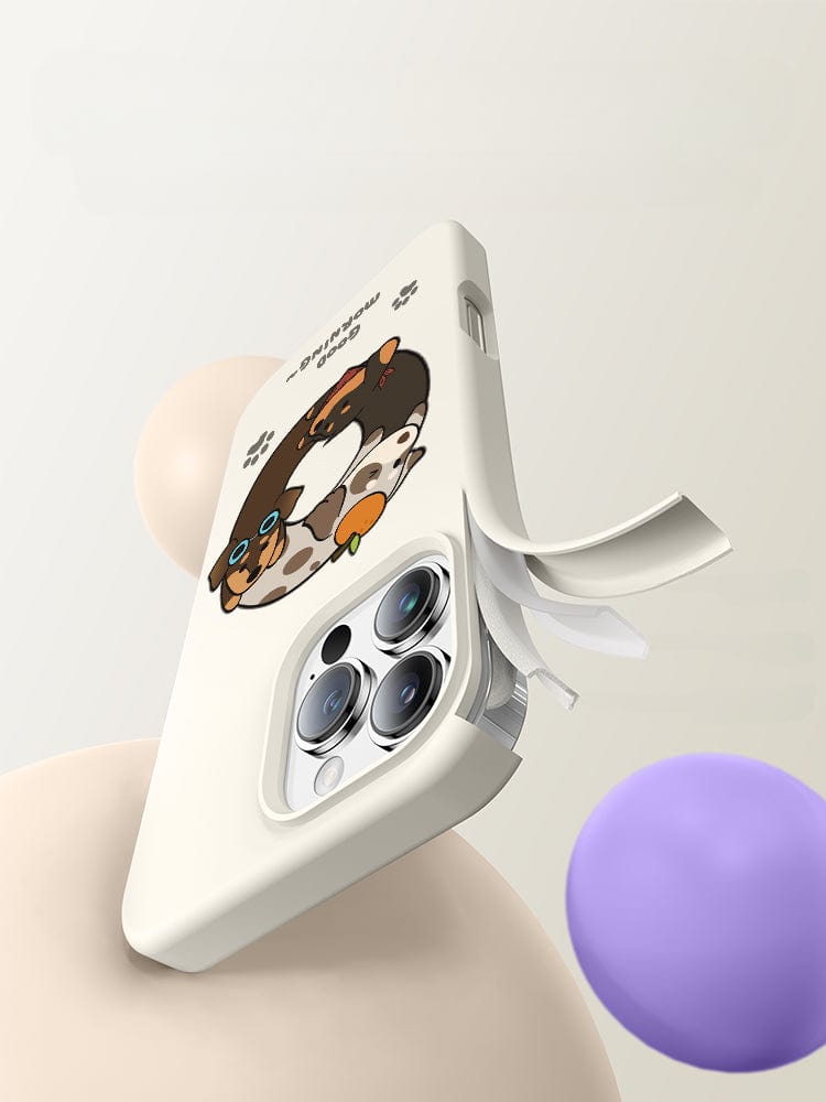 An iPhone 16 Pro Max Case - Good Morning Cartoon Dog Silicone Protective Cover, featuring a partially open compartment, is displayed against a neutral background with floating beige and purple spheres.