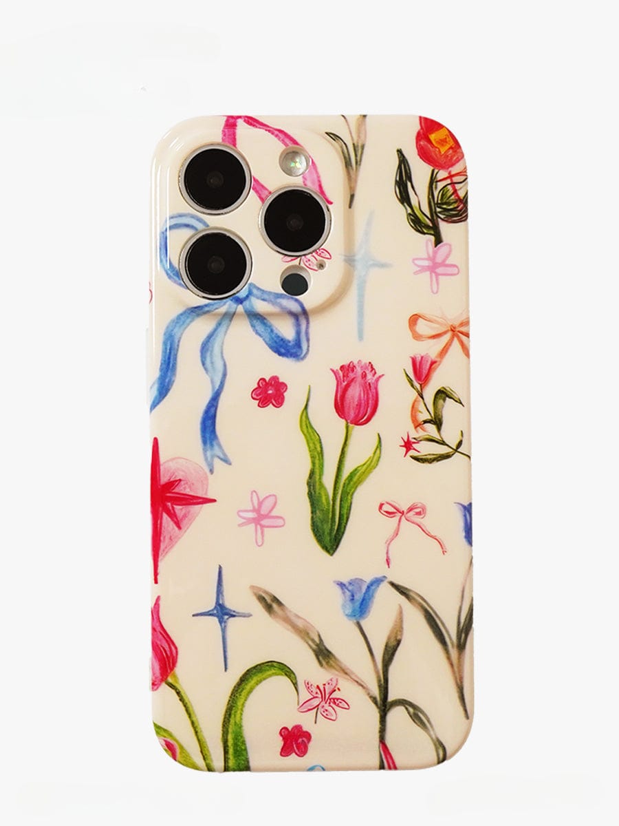 A smartphone encased in the Floral Dreams iPhone 16 Pro Max Case, which showcases a colorful botanical design with drawings of flowers, ribbons, and stars on a white background. The elegant all-inclusive protective cover features cutouts for three cameras and a flash.