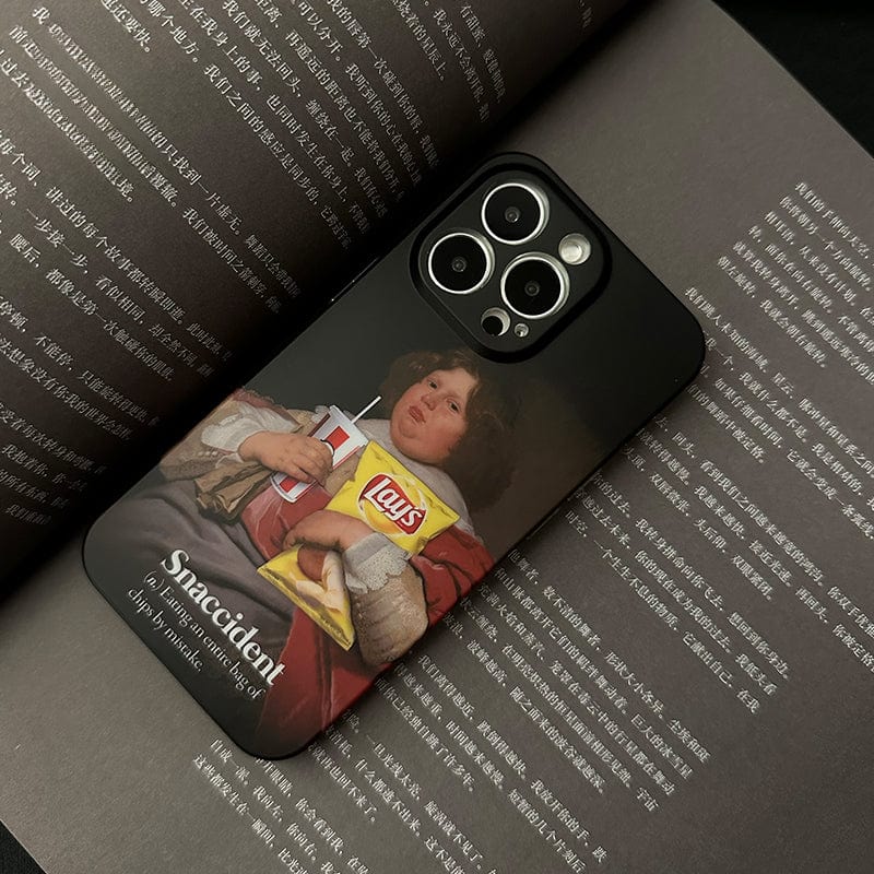 A smartphone with a black case is placed open on a book. The Snaccident iPhone 16 Pro Max Case, adorned with a classical painting of a person holding a drink and a bag of Lay's potato chips, features text that reads "Snaccident: accidentally ate the whole snack.