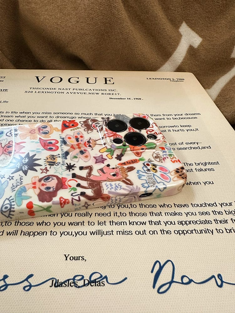 A Whimsical Doodle Art iPhone 16 Pro Max Case, featuring a colorful cartoon design, rests on top of a document bearing the Vogue magazine heading. The background reveals a brown fabric with partially visible white letters.