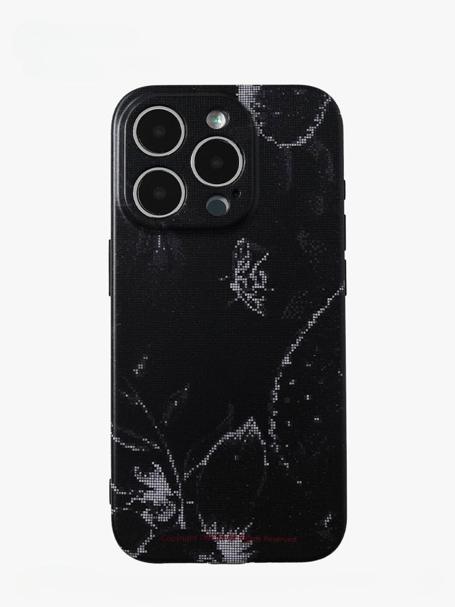 A smartphone displaying the Noir Floral iPhone 16 Pro Max Case is shown from the back, highlighting its three camera lenses and flash. The case features intricate black and white floral-patterned flower and leaf designs, providing a stylish and sophisticated look.