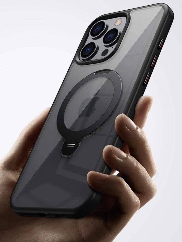 A hand holding the Ultra-Thin iPhone 16 Pro Max Case with a black frame and transparent back, featuring a 360° rotating ring stand, MagSafe compatibility, and shockproof silicone shell. The phone itself showcases a circular magnetic attachment and three camera lenses.