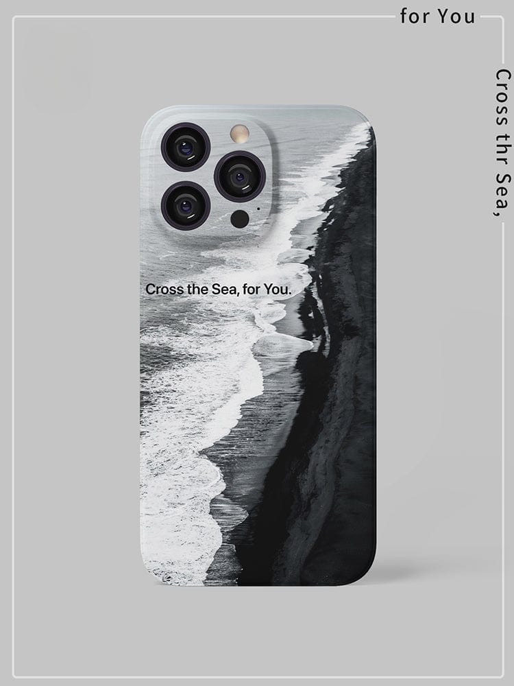 A Monochrome Ocean iPhone 16 Pro Max Case - Minimalist and Protective - rests on a gray surface in a portrait orientation. Its back cover features a black and white aerial view of a coastline, with the text "Cross the Sea, for You" printed across the image and along the borders.