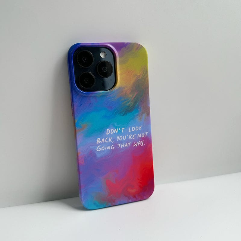 A colorful, ultra-slim case for the iPhone 16 Pro Max featuring a gradient design with swirling shades of blue, green, yellow, and red. The Inspirational Quote iPhone 16 Pro Max Case includes an inspiring message in white text that reads, "DON'T LOOK BACK, YOU'RE NOT GOING THAT WAY." The phone also comes equipped with three rear cameras.