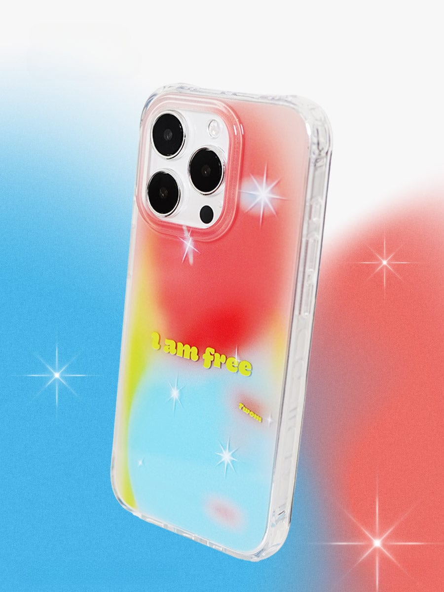 A smartphone encased in the "I Am Free Gradient iPhone 16 Pro Max Case" showcases a vibrant design with red, blue, and yellow gradients and the text "I am free." This reflective, all-inclusive protective cover is semi-transparent to allow visibility of the camera lenses. Sparkles around the phone add a bright and stylish touch.