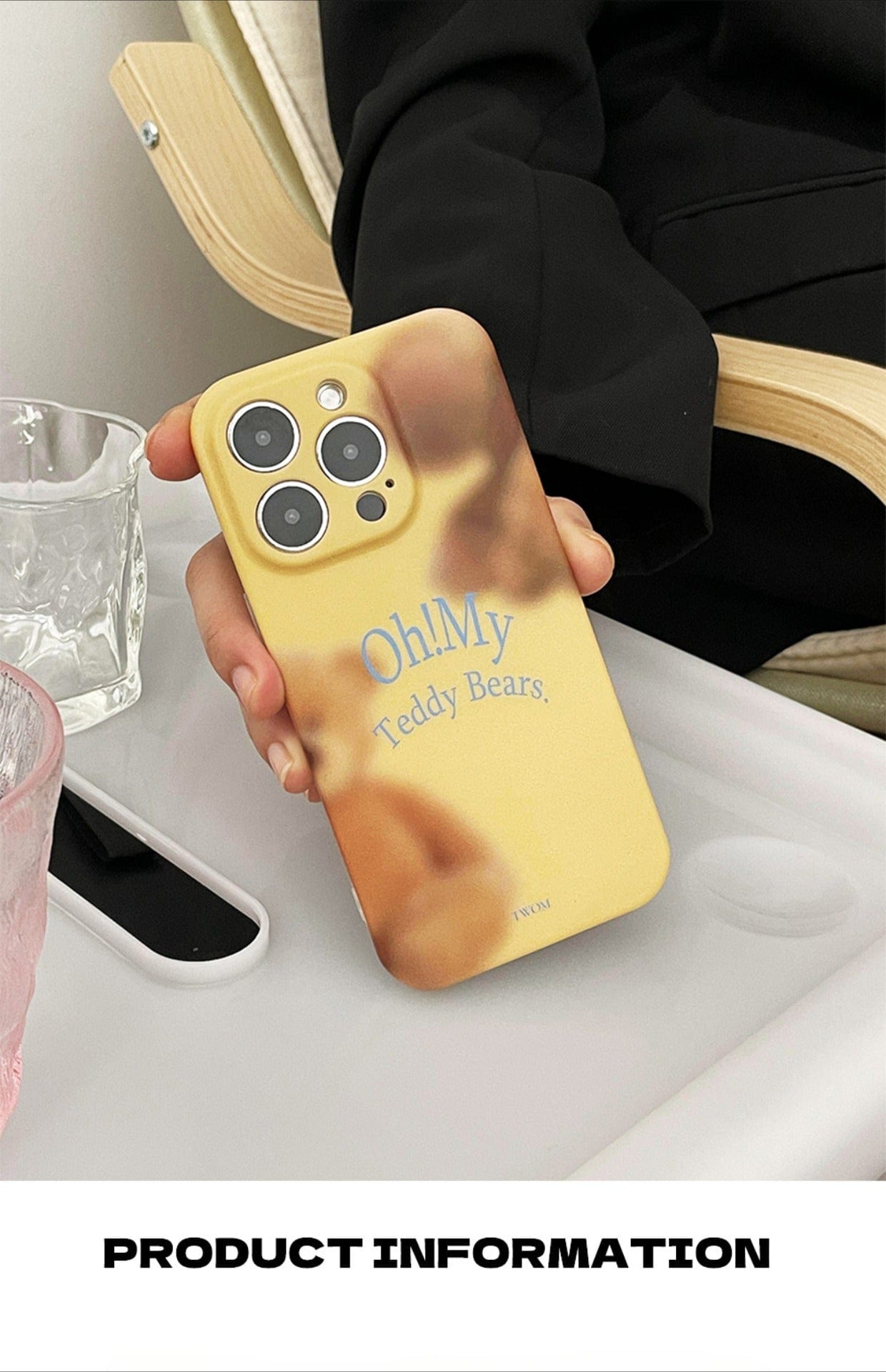 A person holding an iPhone 16 Pro Max encased in a soft matte finish "Oh! My Teddy Bears" protective cover, featuring a blurred teddy bear design. The individual is seated at a white table with a glass of water and another smartphone nearby. Text below the image reads "PRODUCT INFORMATION: Oh! My Teddy Bears iPhone 16 Pro Max Case | Soft Matte Finish | Cute All-Inclusive Protective Cover.