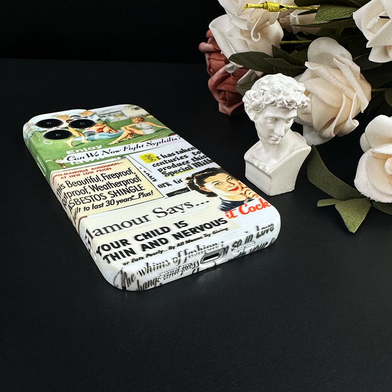 The Vintage Advertisement Collage iPhone 16 Pro Max Case - Retro Pop Art Design with Full Protection rests on a black surface, surrounded by artificial flowers and a small bust sculpture. The case showcases a vintage collage design with various retro advertisements and text.