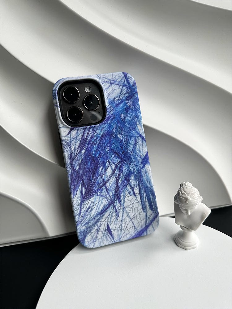 A smartphone with an Abstract Blue Scribble iPhone 16 Pro Max Case - Artistic Design with Full Protection, featuring a blue and white abstract pattern, is leaning against a wavy white textured background. In front of it is a small white bust sculpture, adding an artistic touch to the scene.