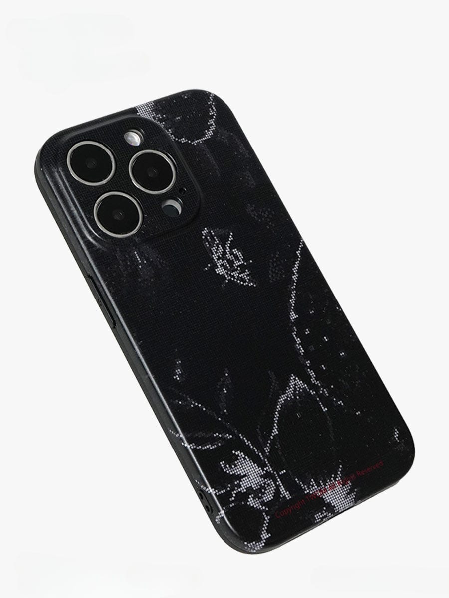 A Noir Floral iPhone 16 Pro Max Case boasting an elegant black and white design with a textured dark floral pattern on its back. The case accommodates three rear cameras and a flash arranged in a triangular configuration at the top left corner, all set against a plain white background.