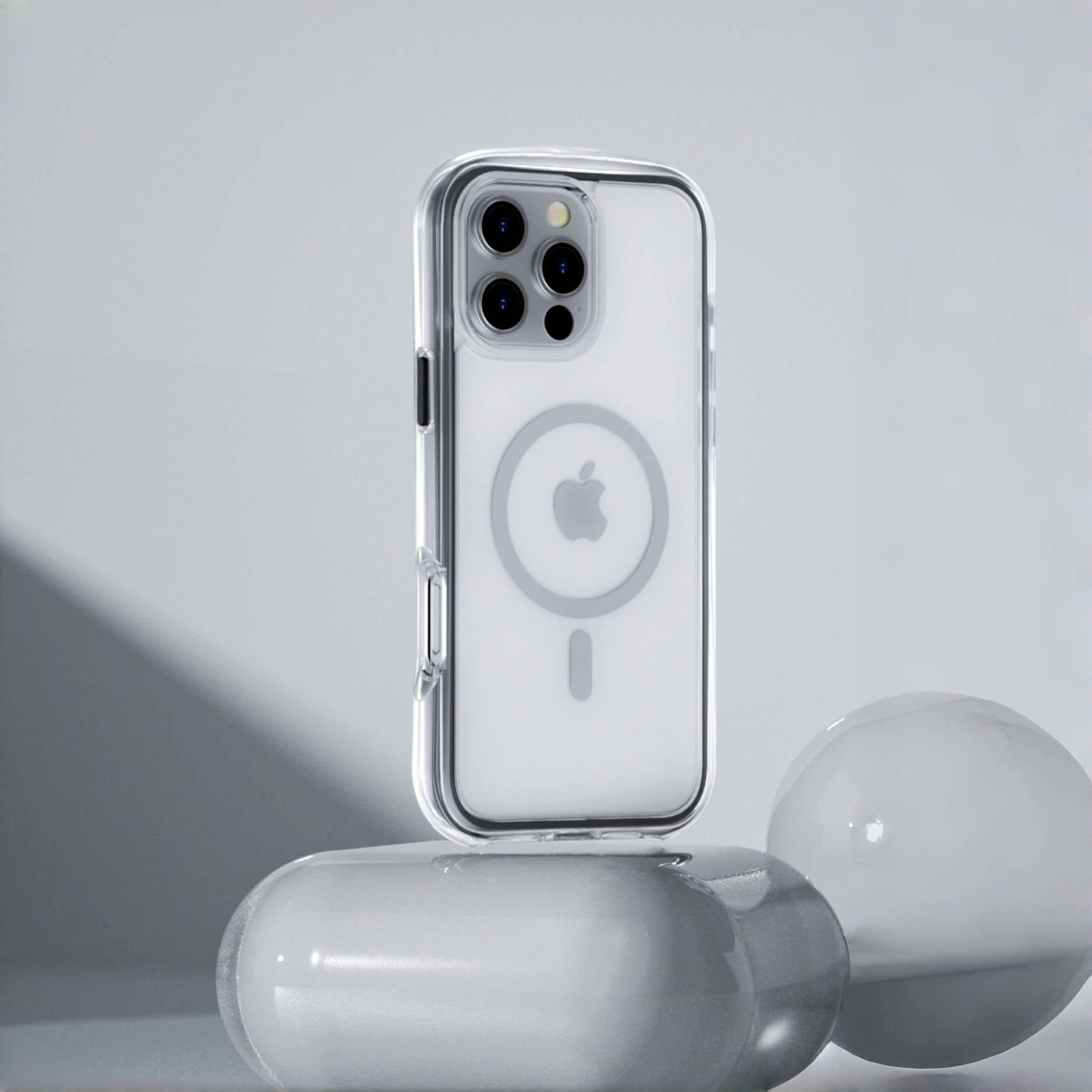 An iPhone 16 Pro Max with an Air Cushion MagSafe Case | 360° Shockproof Clear Protective Cover in grey stands upright on white, rounded objects against a grey background. The transparent case offers excellent shock absorption.