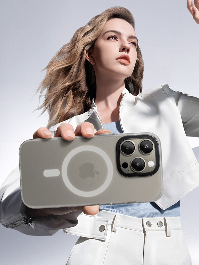 A person with long hair holds a smartphone up towards the camera, showcasing the backside of the device. The iPhone 16 Pro Max MagSafe Case | X-002 Hdens Matte Finish Shockproof Cover features a circular pattern with a logo in the center and an Hdens matte finish, highlighting its sleek design enhanced by F-side shockproof technology.