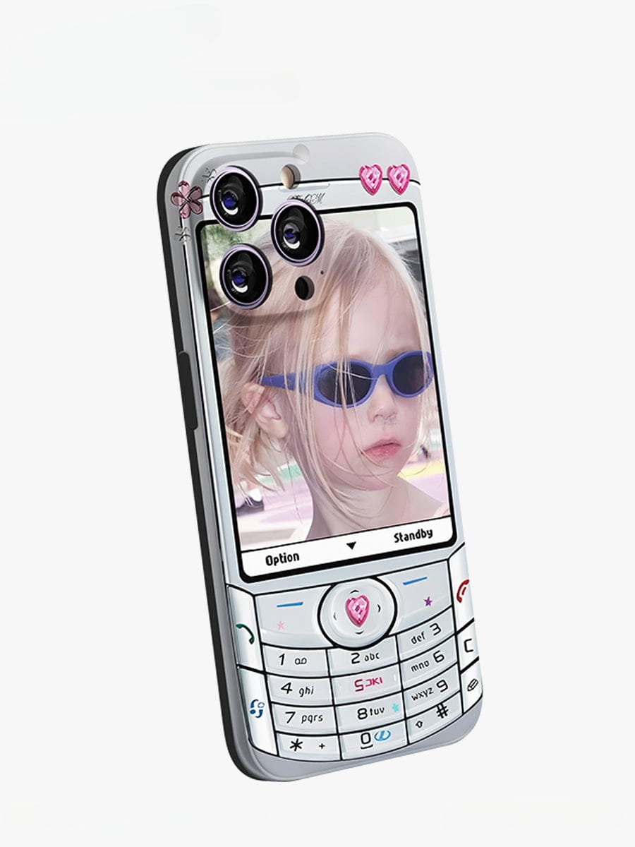 A smartphone case with a retro flip phone design features a young child wearing sunglasses on the screen. The Retro Flip Phone iPhone 16 Pro Max Case, part of the Y2K Nostalgia Design collection, boasts a numeric keypad and button layout reminiscent of old mobile phones. Decorative heart stickers near the camera lenses add extra charm to this fun all-inclusive protective cover.