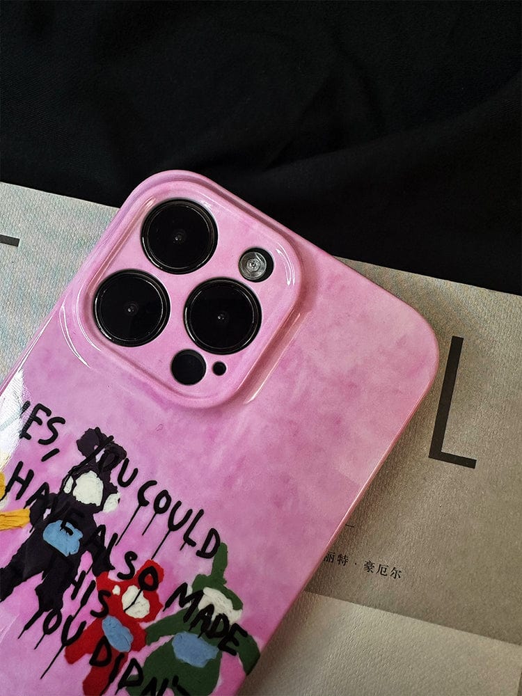 A close-up of a smartphone adorned with the Playful Critique iPhone 16 Pro Max Case in a bold pink design, showcasing unique abstract artwork and the statement, "Yes, you could also made his you drama." The phone rests on a partially visible piece of paper against a dark background.