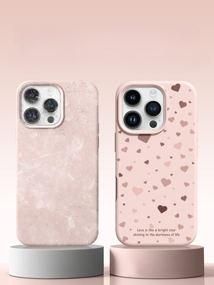 Two smartphones in pink cases are displayed vertically. The left iPhone 16 Pro Max case features a marble-like texture, while the right, named the iPhone 16 Pro Max Case - Soft Liquid Silicone Protective Cover with Shockproof Design and Anti-Fingerprint Coating, is decorated with scattered hearts and a small quote near the bottom.