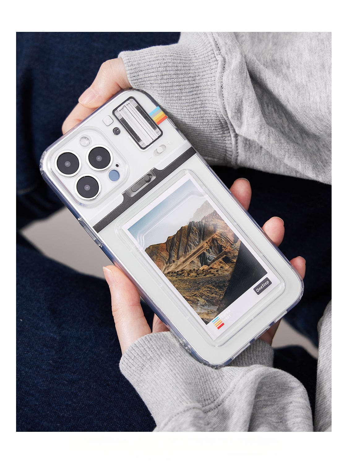 A person holds an iPhone 16 Pro Max with a Polaroid Frame MagSafe case, featuring a customizable photo holder design with a picture of a mountainous landscape.