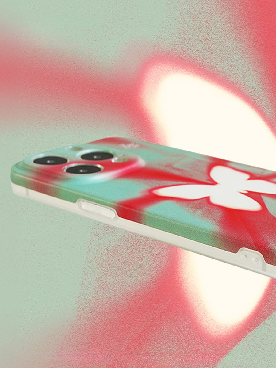 The Butterfly Aura iPhone 16 Pro Max Case, featuring a vivid gradient design with a white butterfly, is displayed against a blurred red and green background.