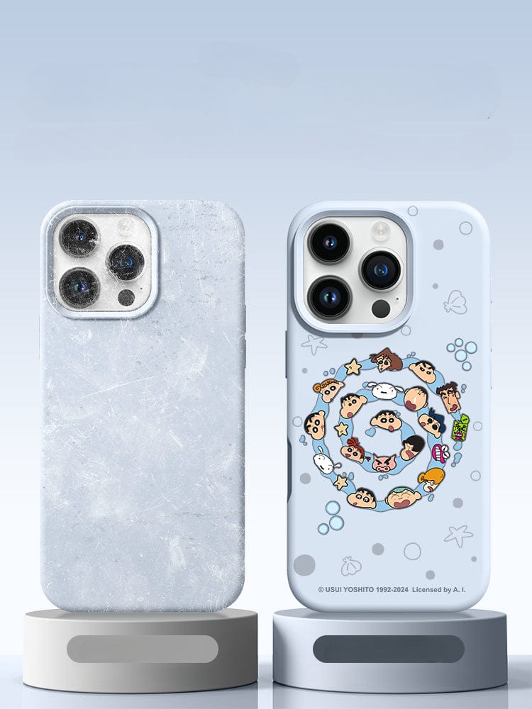 Two smartphones on stands. The left phone features a textured, translucent case with triple-layer shockproof protection. The right phone sports an iPhone 16 Pro Max Crayon Shin-chan Case made of light blue premium liquid silicone, offering shockproof and anti-dust protection, adorned with Crayon Shin-chan characters in a circular pattern.