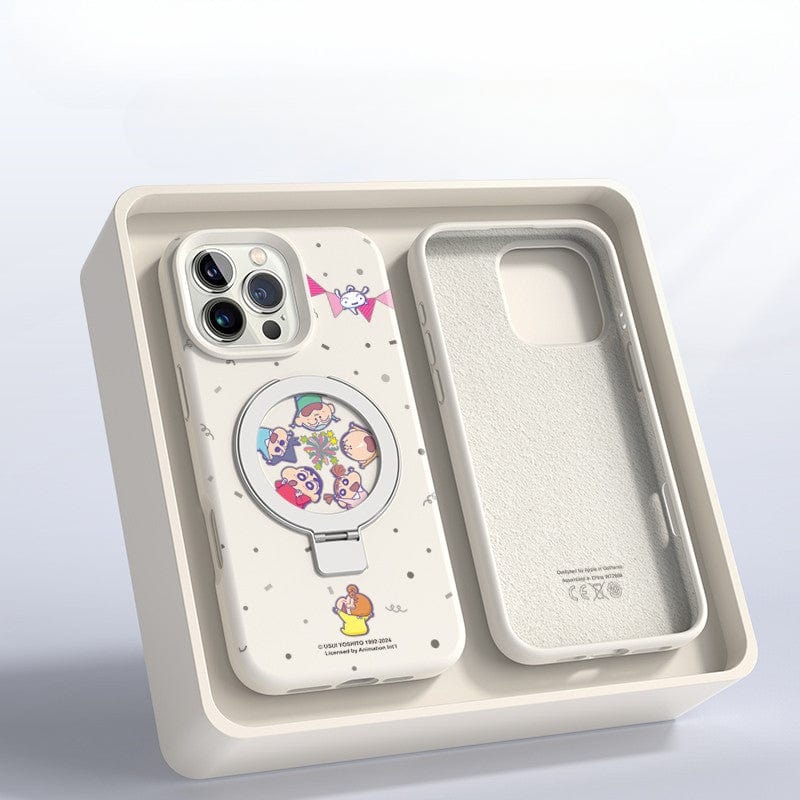 An iPhone 16 Pro Max Cartoon MagSafe Case made of liquid silicone, featuring a ring stand and a circular cartoon character design, is displayed next to an empty phone-shaped slot in a beige tray.