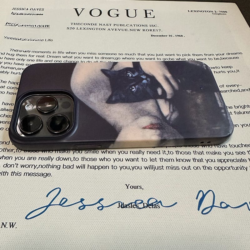 An Artistic Portrait iPhone 16 Pro Max Case featuring a vintage black cat and woman design provides an ultra-slim, full protection for the smartphone, placed on a paper containing written text and the Vogue magazine logo. The letter is signed with a large, stylized signature.