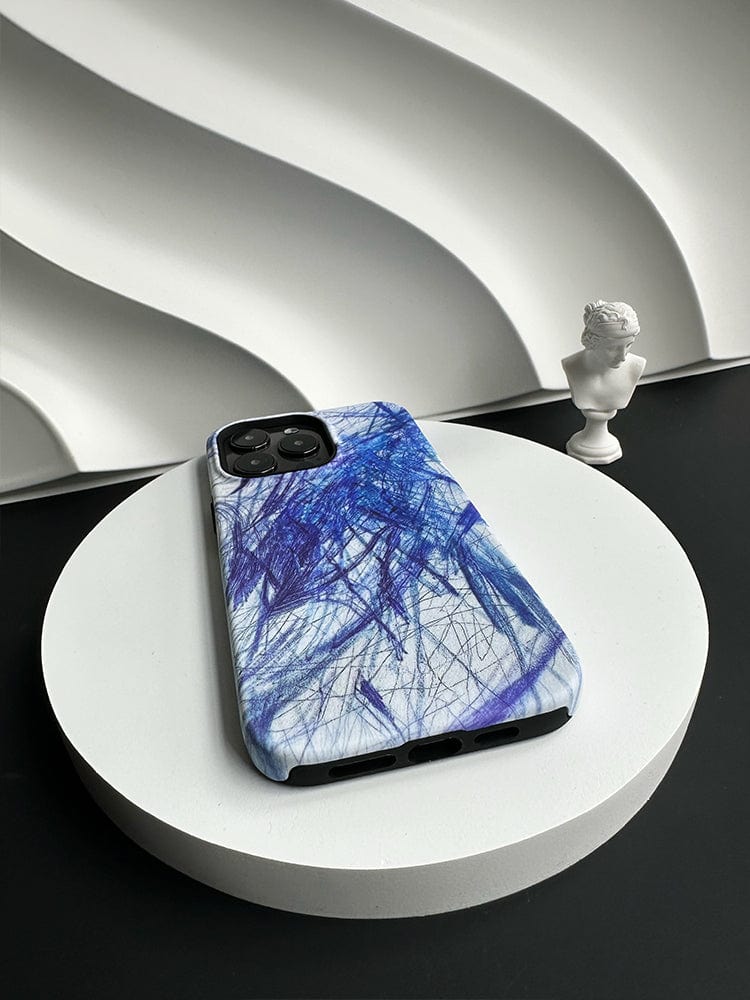 A smartphone with an Abstract Blue Scribble iPhone 16 Pro Max Case, renowned for its artistic design and full protection, is placed on a white circular platform. A small white bust sculpture is positioned to the right of the phone, set against a backdrop of an abstract, wavy, white surface.