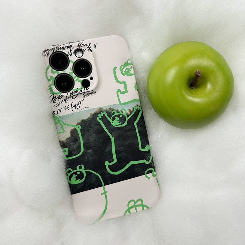 A smartphone with a Unique Green Bear Graphic iPhone 16 Pro Max Case - Creative Forest Art Design, Ultra-Slim, Full-Edge Protection is placed on a soft white surface. Next to the phone is a bright green apple.