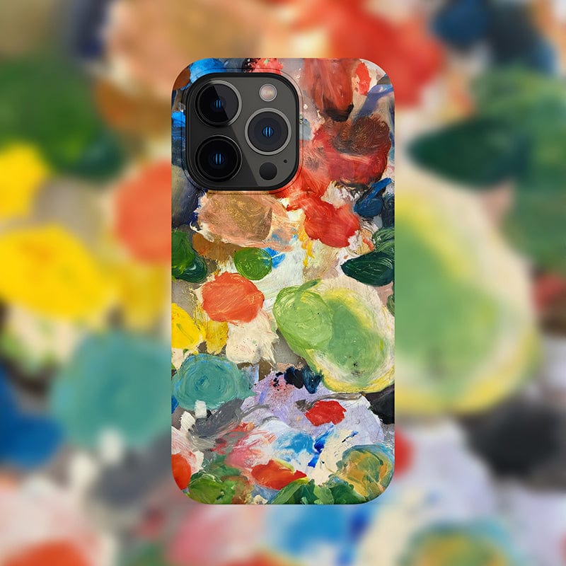 The Abstract Paint Palette iPhone 16 Pro Max Case - Artistic and Protective features a design reminiscent of an abstract painting with vibrant hues of red, green, blue, yellow, and white. It resembles a palette of mixed paints and is set against a blurred background with similar abstract patterns.