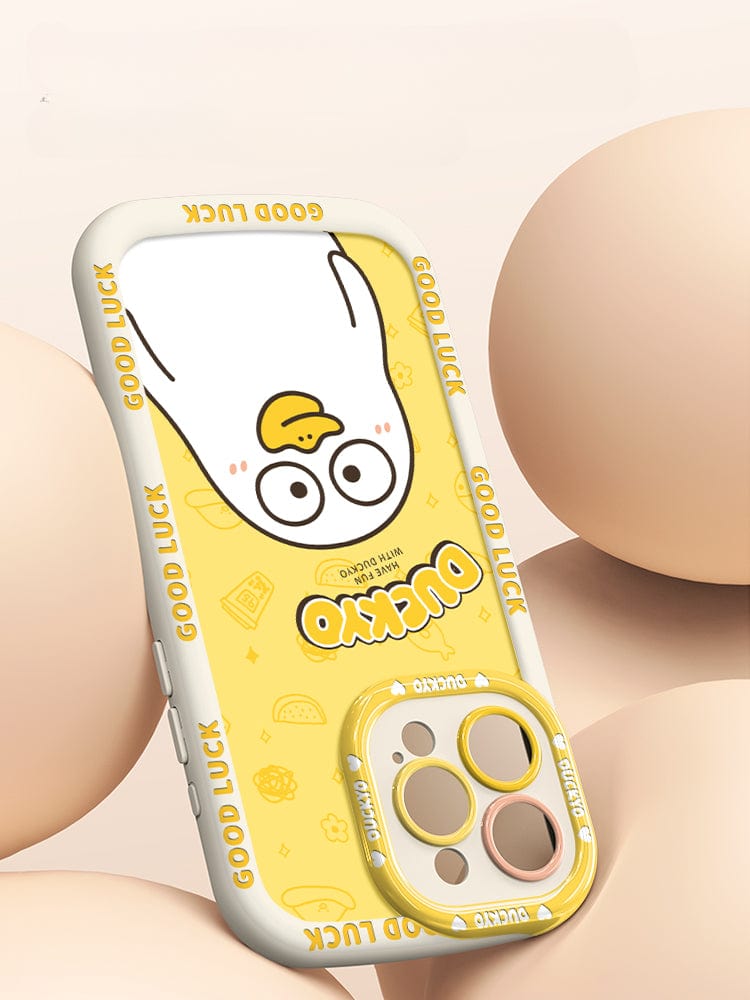 A yellow iPhone 16 Pro Max Yellow Duck Cartoon Case, featuring a soft liquid silicone protective cover with a cute design of a cartoon character surrounded by multiple beige-colored eggs. The case displays the text "Good Luck" along the edges and offers both style and shockproof protection.