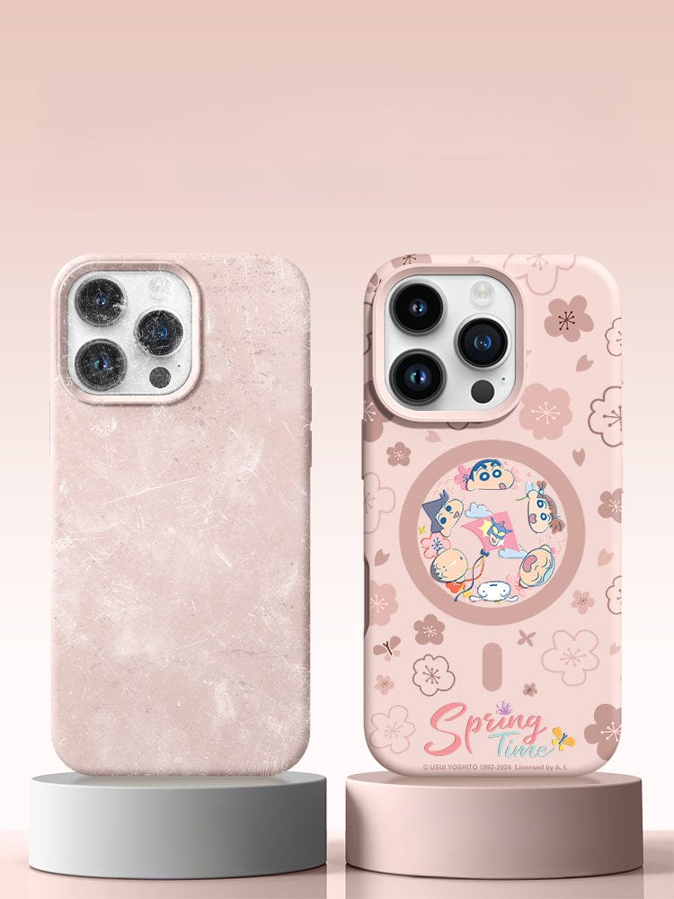 Two smartphones with pink cases are displayed on round podiums. The left case, an iPhone 16 Pro Max cover, is plain pink and textured. The right case, named "Spring Time Cartoon Silicone Protective Cover," features a floral design with cartoon characters and the text "Spring Time," offering full-coverage protection with a shockproof design and anti-yellowing coating for your device.