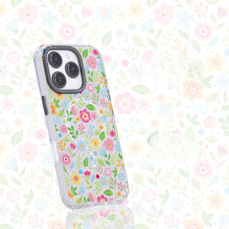 A shockproof smartphone adorned with a 3D floral-patterned case stands upright against a matching floral background, highlighting its exquisite design. The Floral MagSafe iPhone 16 Pro Max Case, featuring a TPU + PC protective shell, is also MagSafe compatible for seamless charging and accessory attachment.