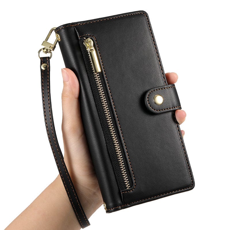 Hand holding an iPhone 16 Pro Max Wallet Case with Card Holder, Zipper Pocket, and Stand Function made of premium black leather with gold hardware and a wrist strap.