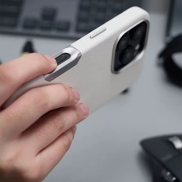 A hand holding a smartphone with an iPhone 16 Pro Max leather case, which includes a raised camera frame and features electroplated aluminum alloy buttons near the lens.