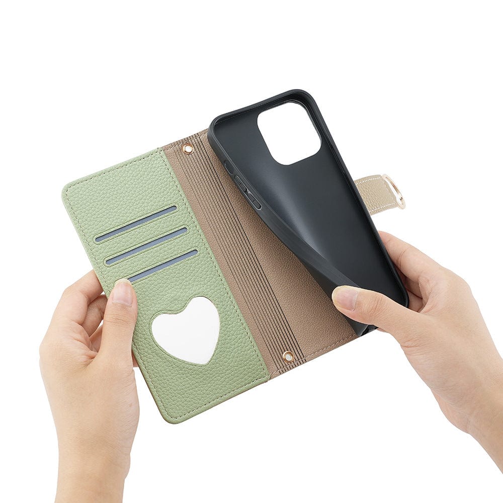 A person holding an open iPhone 16 Pro Max Crossbody Wallet Case made of PU Leather, featuring card slots, a heart-shaped cutout on one side, and a black phone on the other side.