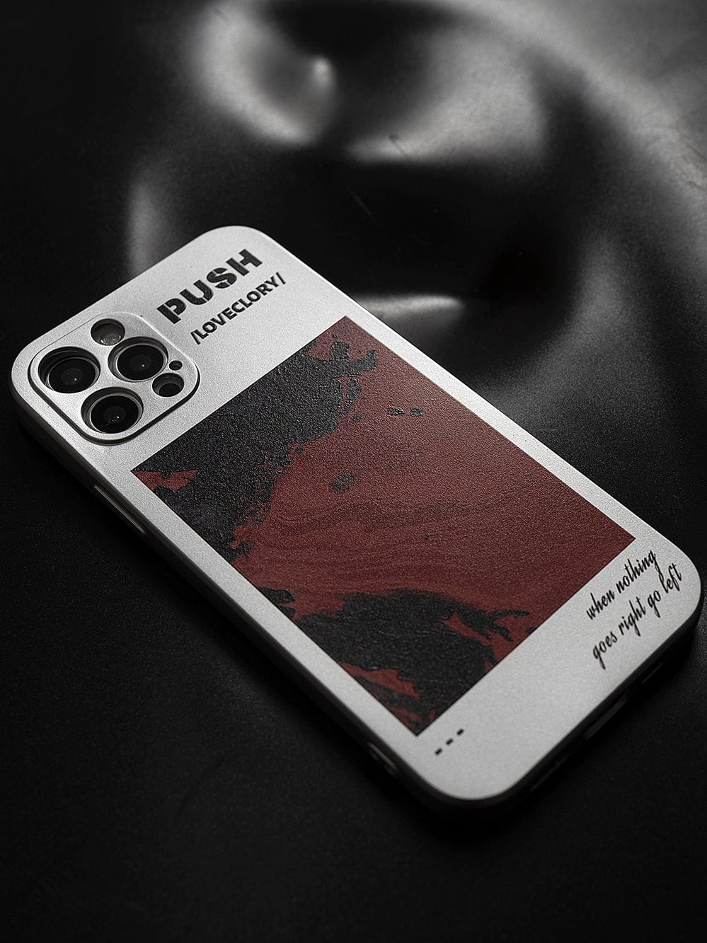 Close-up of the PUSH LoveGlory iPhone 16 Pro Max Case showcasing a bold red and black abstract design, featuring the words "PUSH," "LOVEGLORY," and the motivational phrase "where nothing goes right go left.