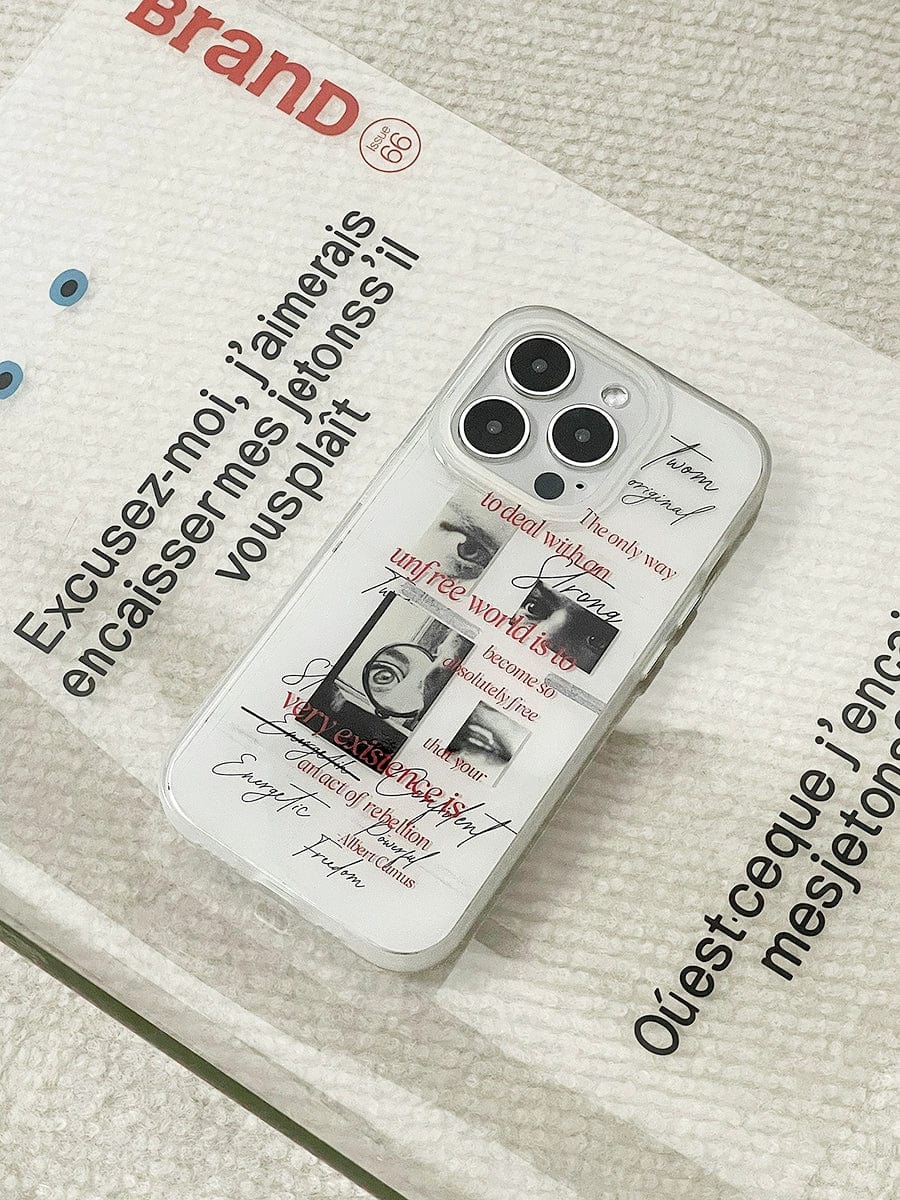 A smartphone encased in the Existential Freedom iPhone 16 Pro Max Case, showcasing black-and-white images with red text. The phone rests on a fabric surface next to a card printed with French text.