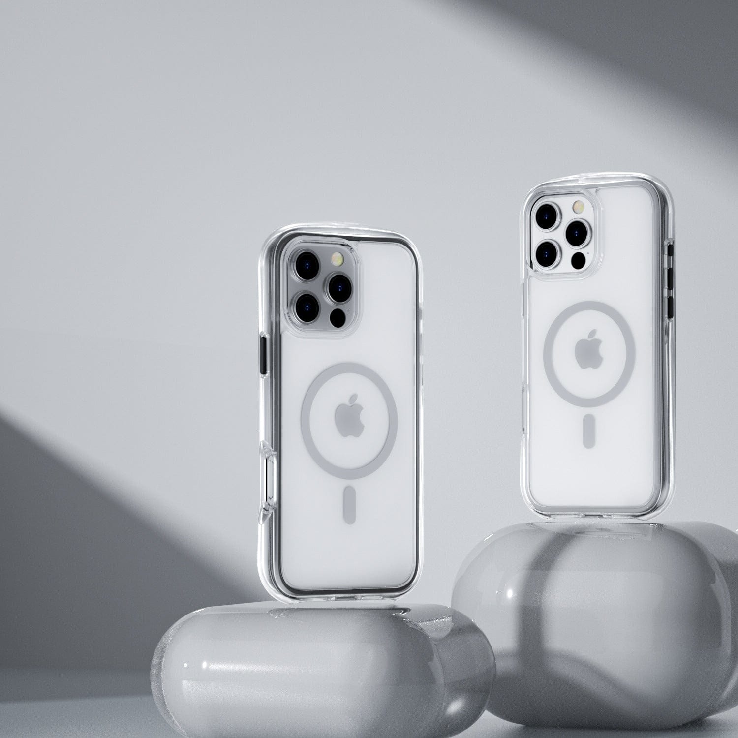 Two iPhone 16 Pro Max devices in clear Air Cushion MagSafe cases, displaying visible Apple logos and MagSafe rings, are showcased on white, rounded pedestals against a gray backdrop to highlight the 360° shockproof features of the new iPhone 16 Pro Max Air Cushion MagSafe Case.