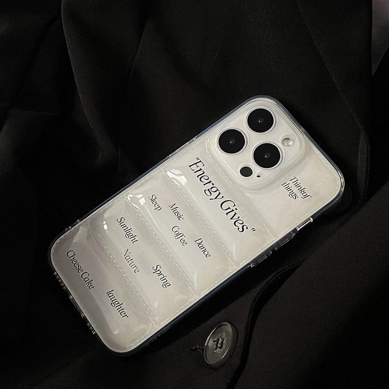 A sleek **Energy Gives iPhone 16 Pro Max Case** with a clear design displaying the words "Energy Gives" and a list of sources including sleep, music, nature, coffee, sunshine, and laughter rests on a dark fabric background.