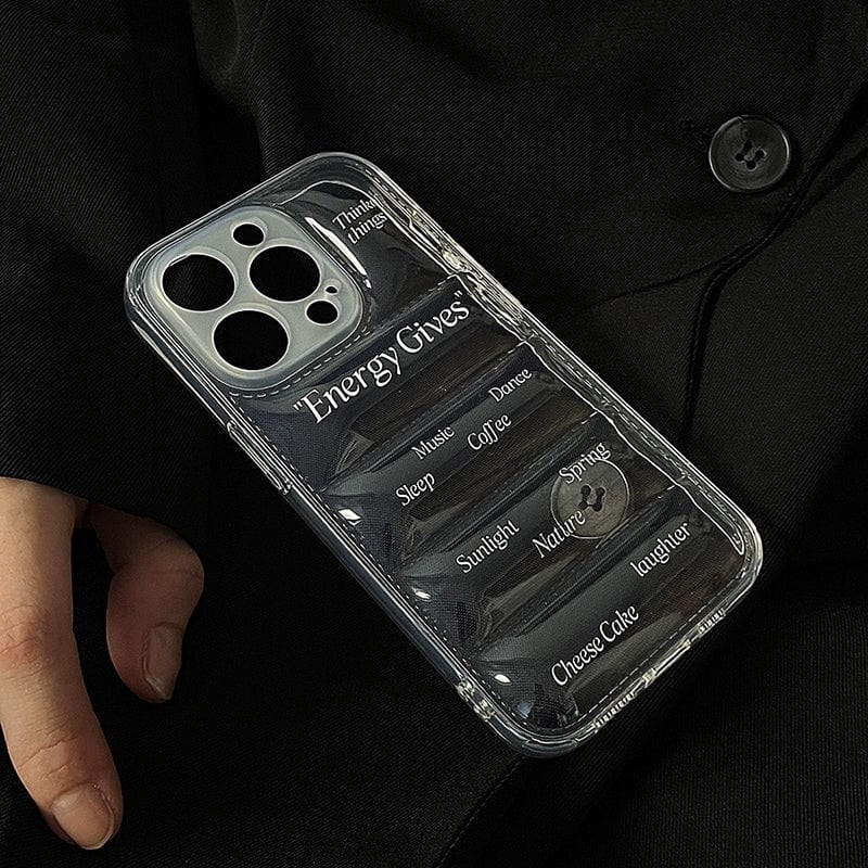 A person holds a transparent Energy Gives iPhone 16 Pro Max Case, an all-inclusive protective cover with a motivational design featuring cutouts and words like music, sunlight, and laughter against a dark background.