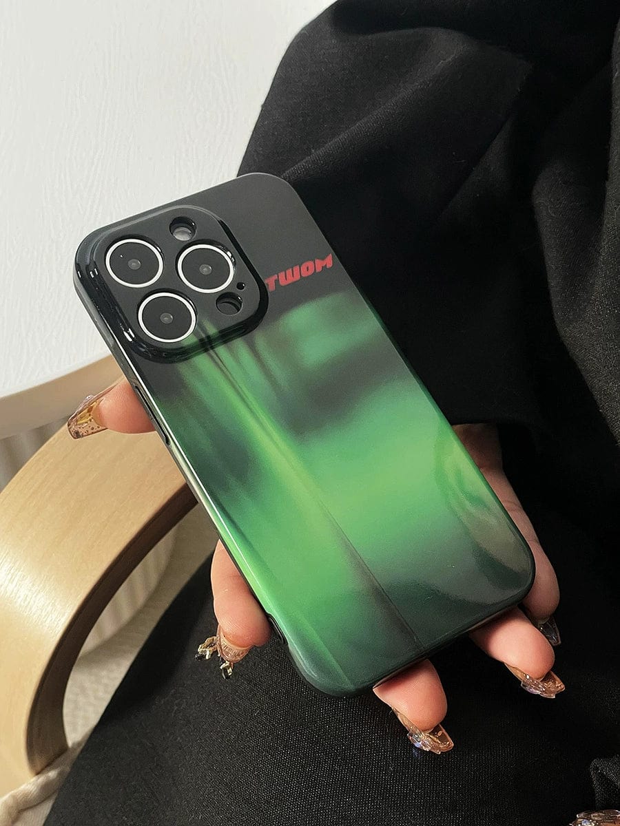 Close-up of a hand holding an iPhone 16 Pro Max adorned with the Aurora Green Gradient Case, featuring a sleek Northern Lights design and red text near the top left corner. The phone boasts an elegant triple camera setup.