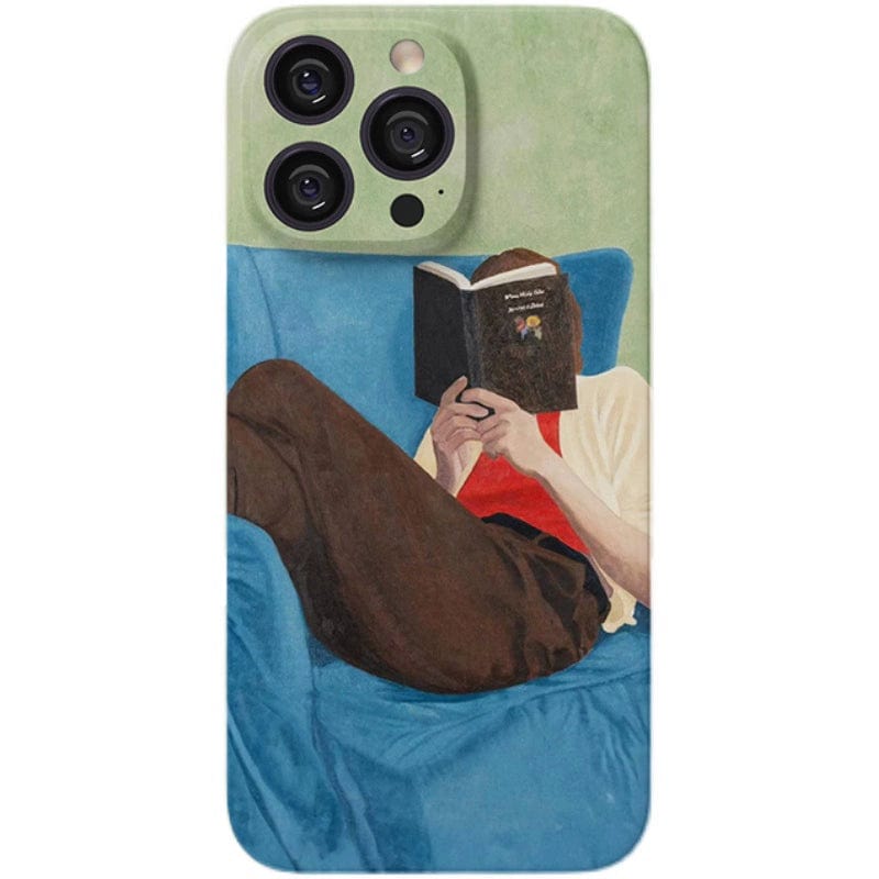 The Relaxed Reader iPhone 16 Pro Max Case - Artistic and Protective, showcases a stylish design of a person lounging on a blue couch, dressed in brown pants, a red shirt, and a white jacket. They are holding and reading a book titled "Open Mind for Beginners," which obscures their face, set against a vibrant green background.