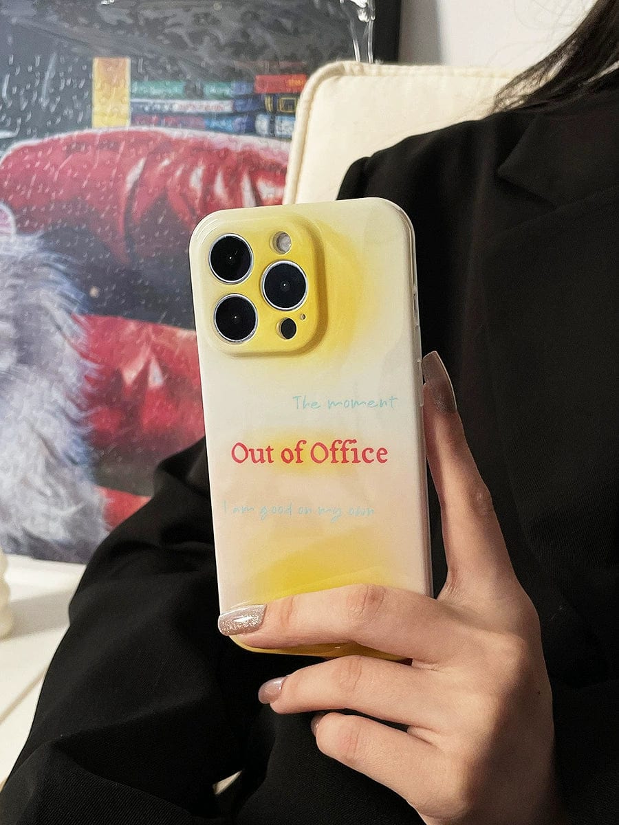 A person in black clothing holds a smartphone with the Out of Office iPhone 16 Pro Max Case, featuring a gradient yellow design and the phrase "I am good on my own." A colorful background is visible.