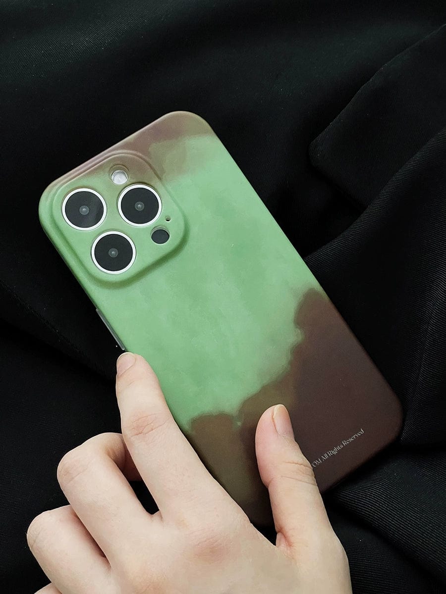 A hand holding an iPhone 16 Pro Max with a Midnight Galaxy iPhone 16 Pro Max Case featuring a cosmic starry design, showing the back side of the phone with its three camera lenses visible. The phone is resting on a black fabric background.