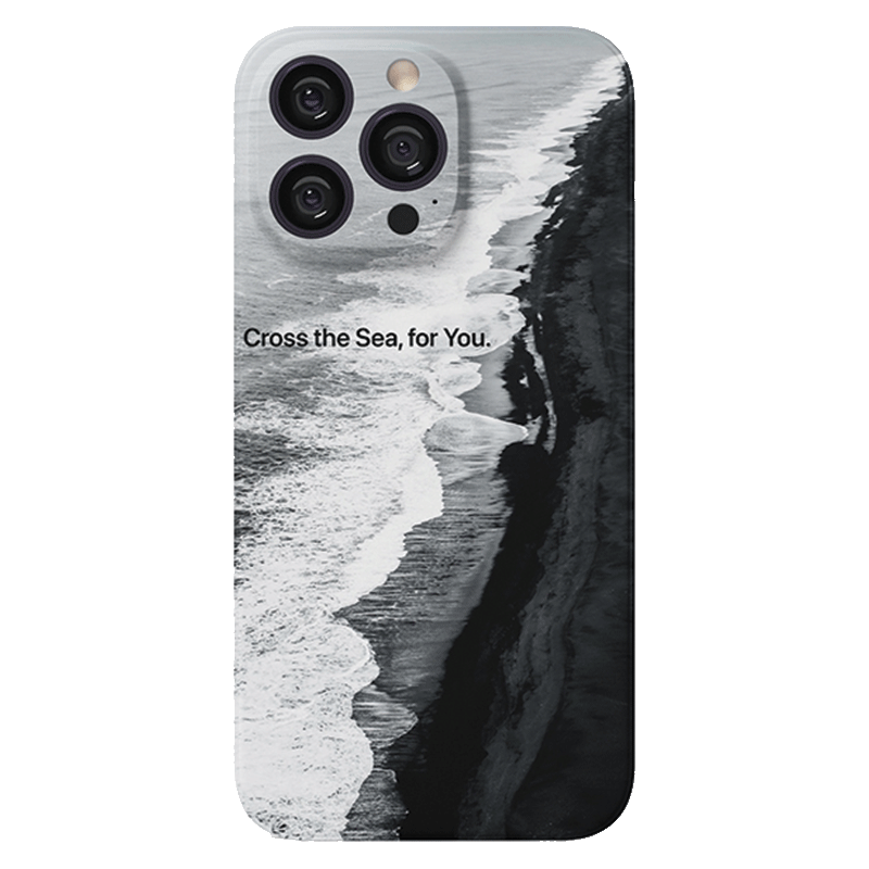 A smartphone with a Monochrome Ocean iPhone 16 Pro Max Case - Minimalist and Protective, featuring a black and white image of a coastal scene with waves crashing against a rugged shoreline. The text "Cross the Sea, for You." is printed across the upper middle part of the case. The phone has three visible camera lenses.