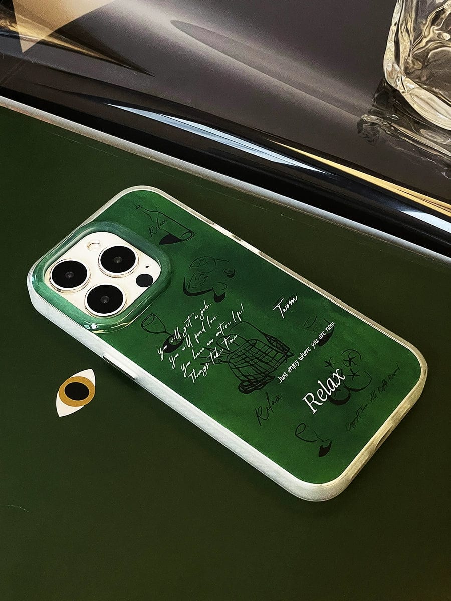 A Relax Green iPhone 16 Pro Max Case with a white edge encases a smartphone displaying various sketches and handwritten text, lying on a dark green surface.