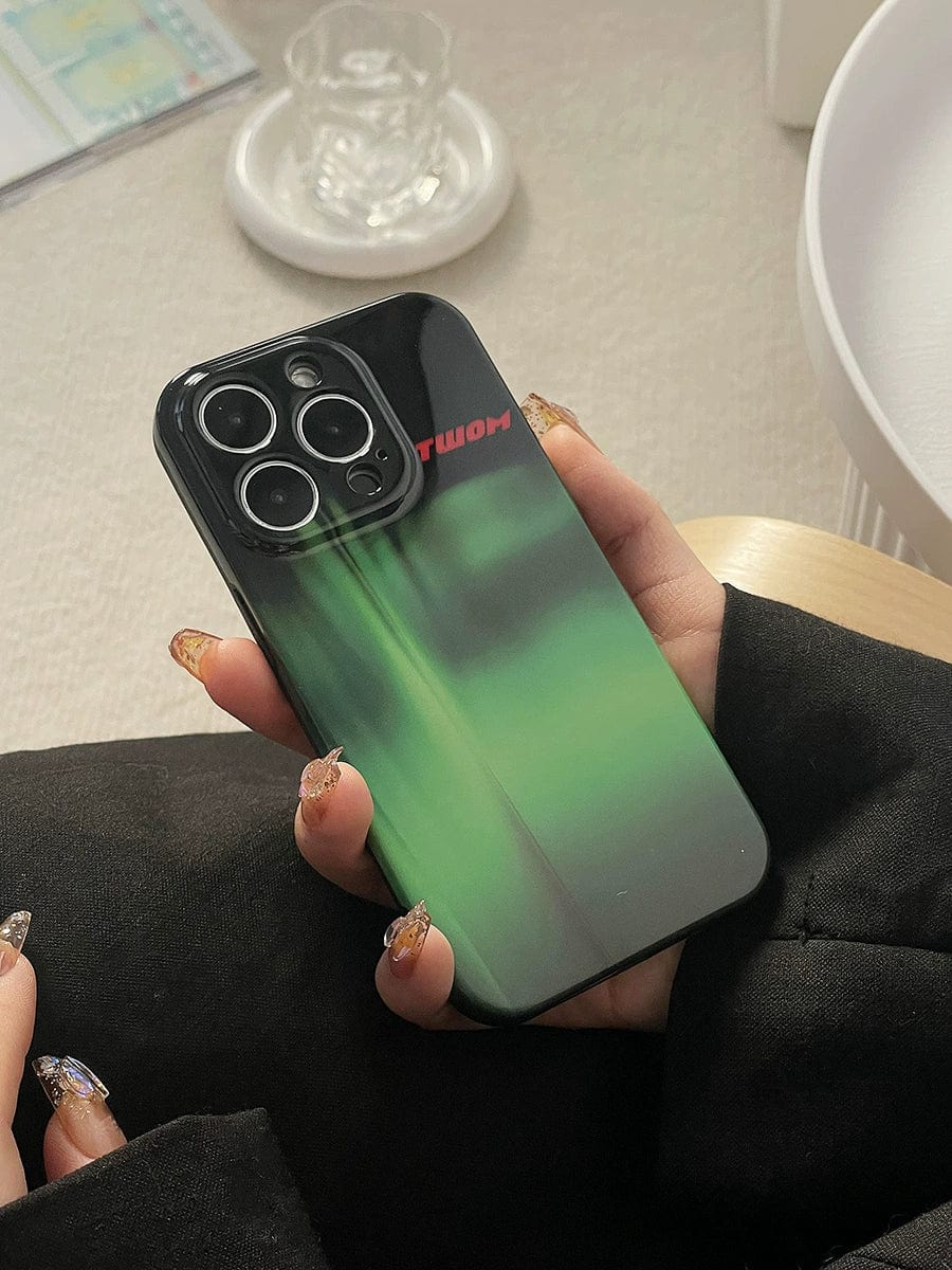 A person holds a smartphone encased in an Aurora Green Gradient iPhone 16 Pro Max Case, featuring a sleek Northern Lights design and showcasing the rear camera lenses. Their nails are adorned with intricate designs.