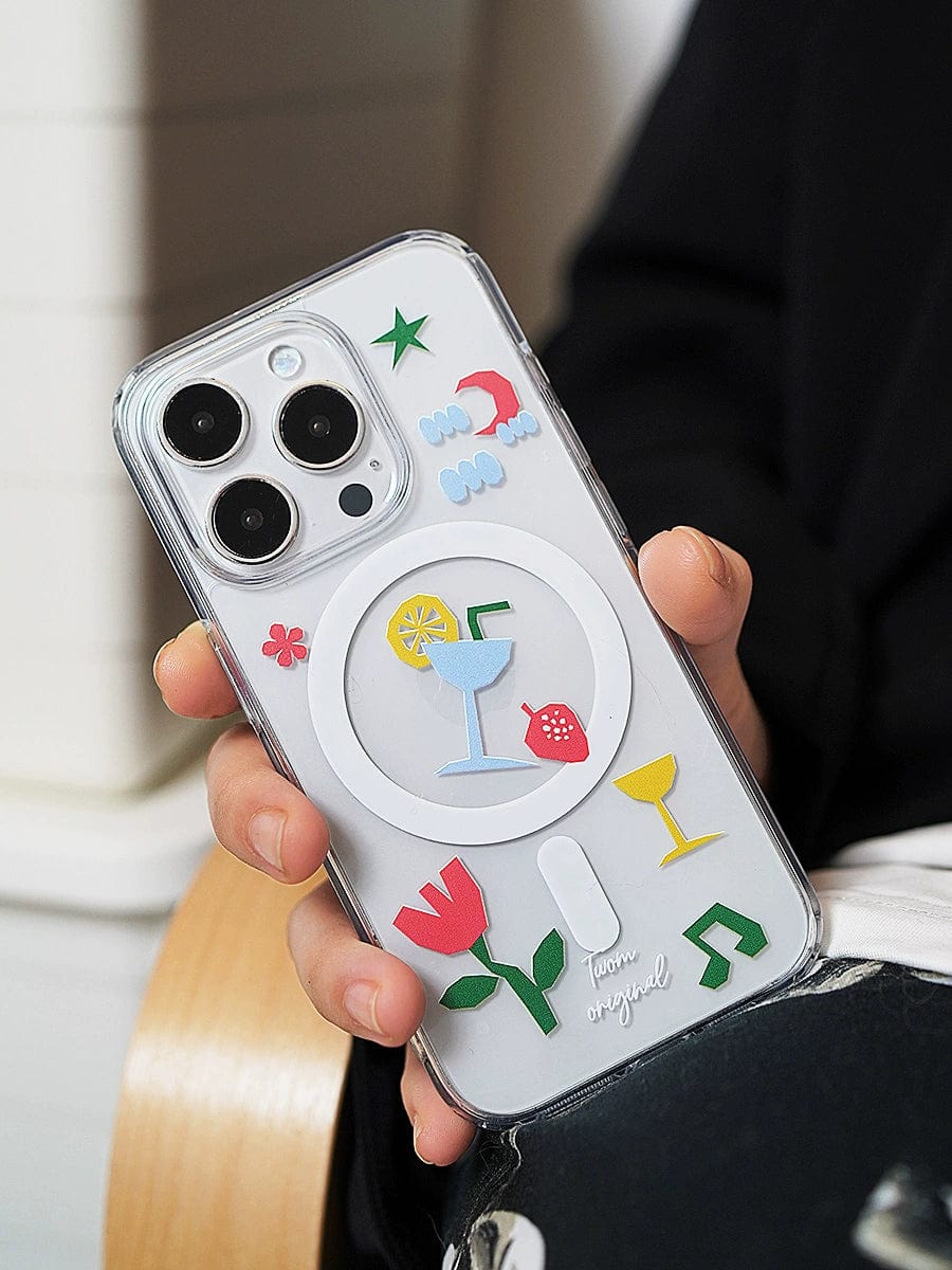 A person holds a Tropical Vibes MagSafe iPhone 16 Pro Max Case, a fun all-inclusive protective cover with colorful 3D elements featuring various stickers, including a cocktail glass, strawberry, tulip, hearts, and musical notes.