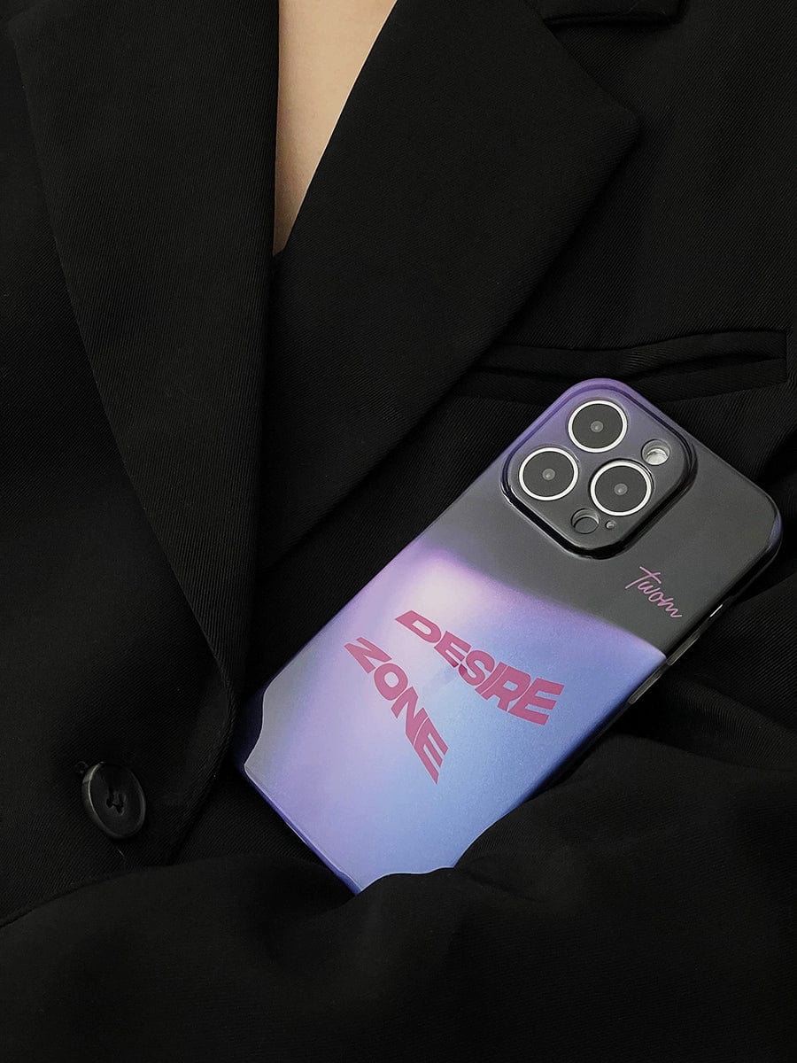 A person wearing a black blazer is holding a smartphone with a Desire Zone iPhone 16 Pro Max Case in their chest pocket. The gradient urban-style case features the words "DESIRE ZONE" in bold red letters and the name "Tooma" near the corner of the phone.