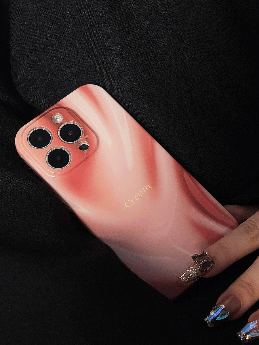 A hand with elaborately decorated nails holds a "Silky Rose iPhone 16 Pro Max Case," featuring a glossy, pink marbled finish labeled "Cream." The phone's triple camera setup is visible on the back. The dark background accentuates both the phone and the intricately designed nails.