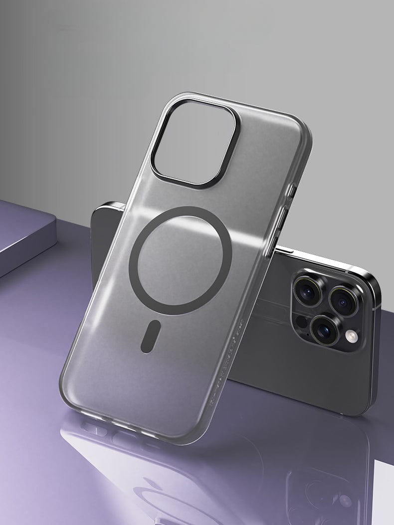The iPhone 16 Pro Max Frosted Semi-Transparent MagSafe Case, featuring a circular design in the center for full body protection, is displayed standing against a smartphone with three rear cameras on a reflective surface. This case offers anti-fingerprint and shockproof protection.
